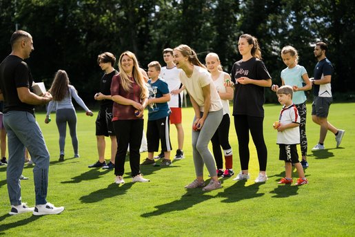 Menschen unterschiedlichen Alters stehen auf einer Wiese